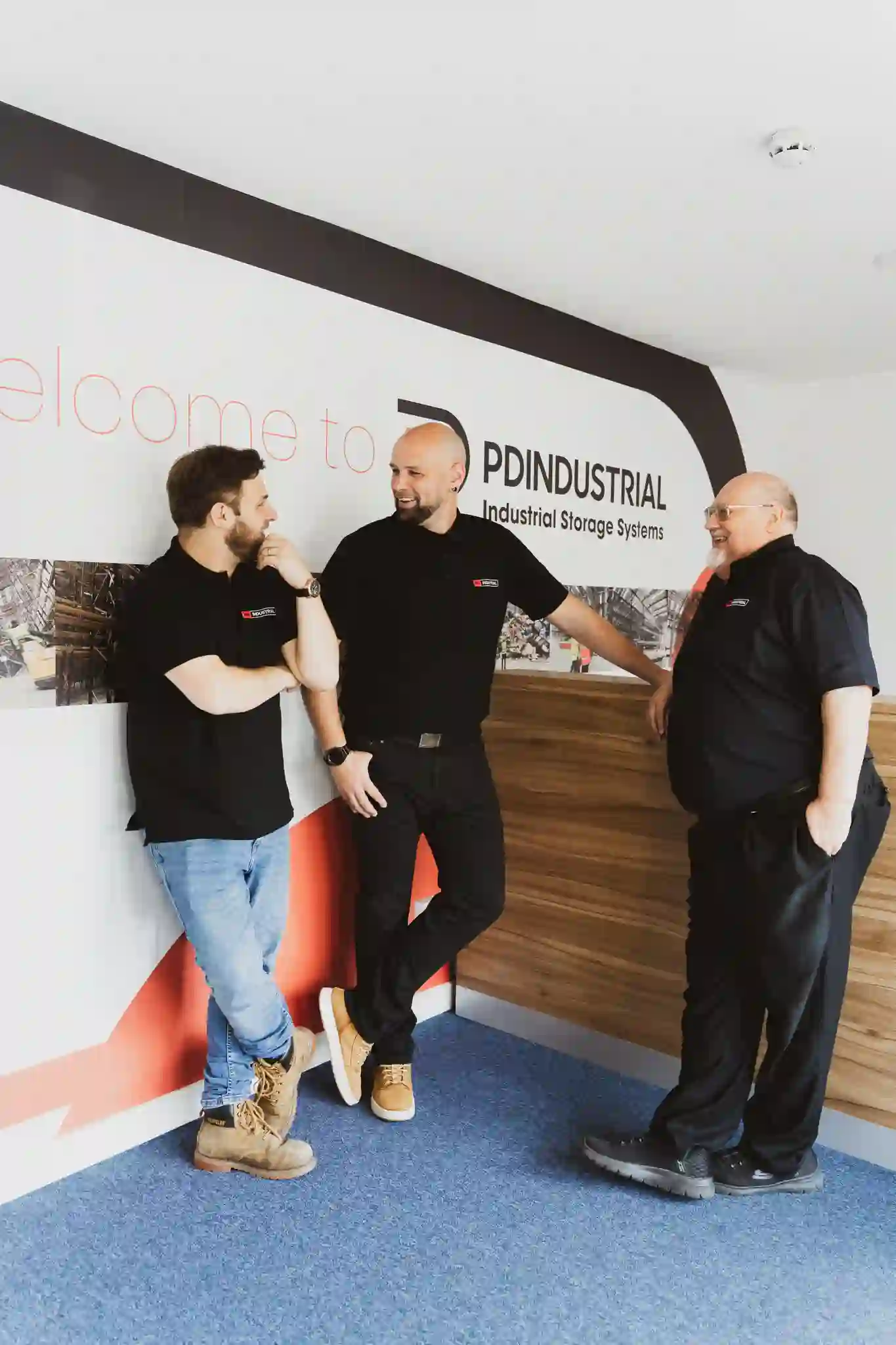 Three members of the PD Industrial team laughing together in the reception area